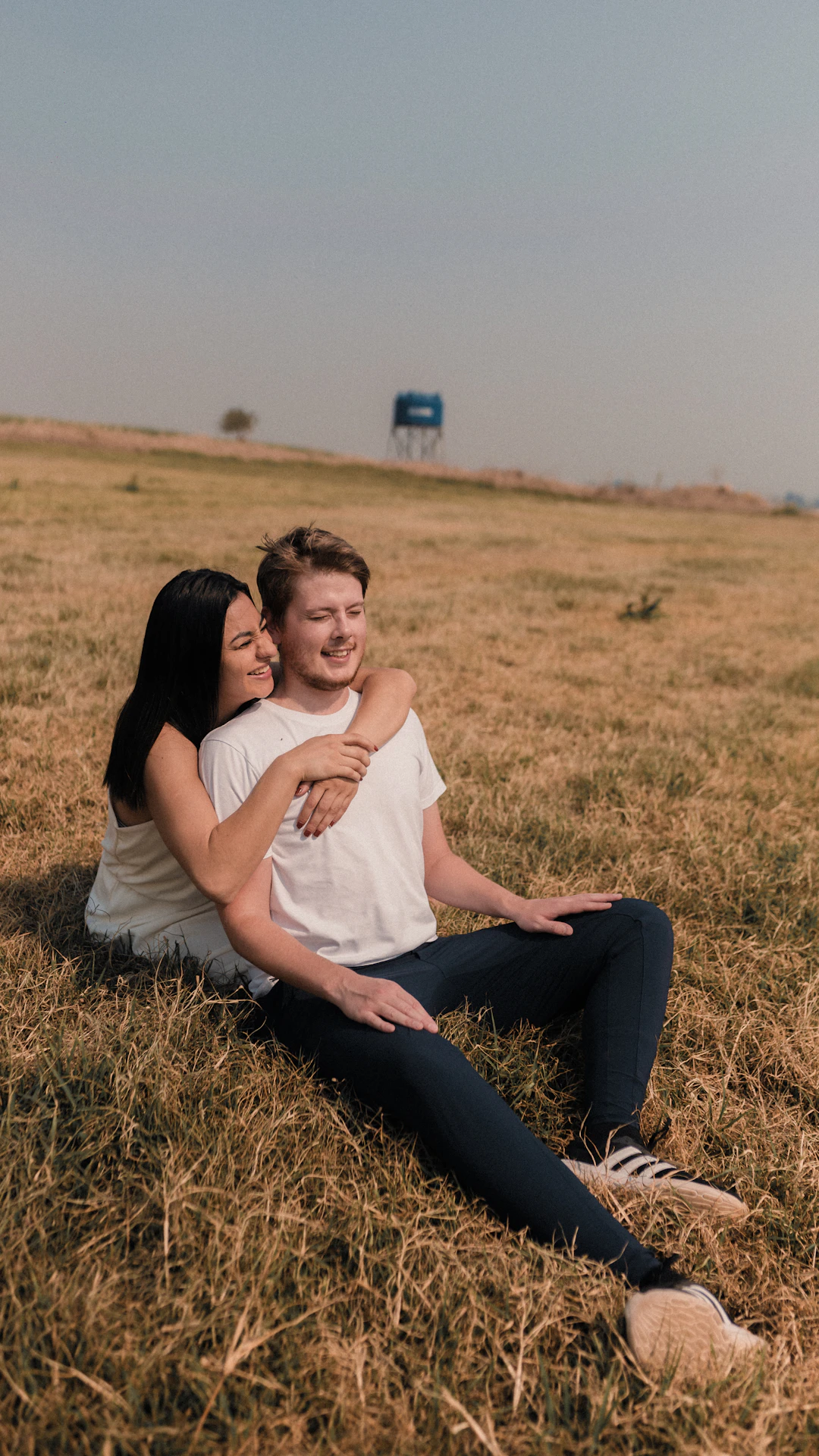 A man and a woman sitting in a field