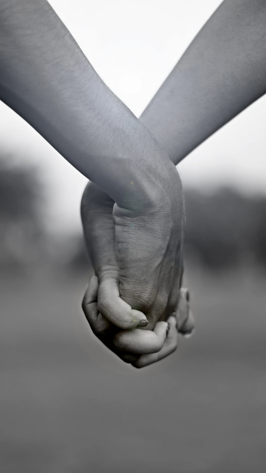 grayscale photo of two person holding hands