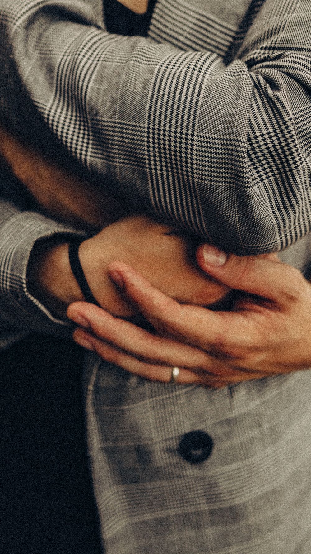 Intimate close-up of a couple holding hands, showcasing tenderness in Balneário Camboriú.
