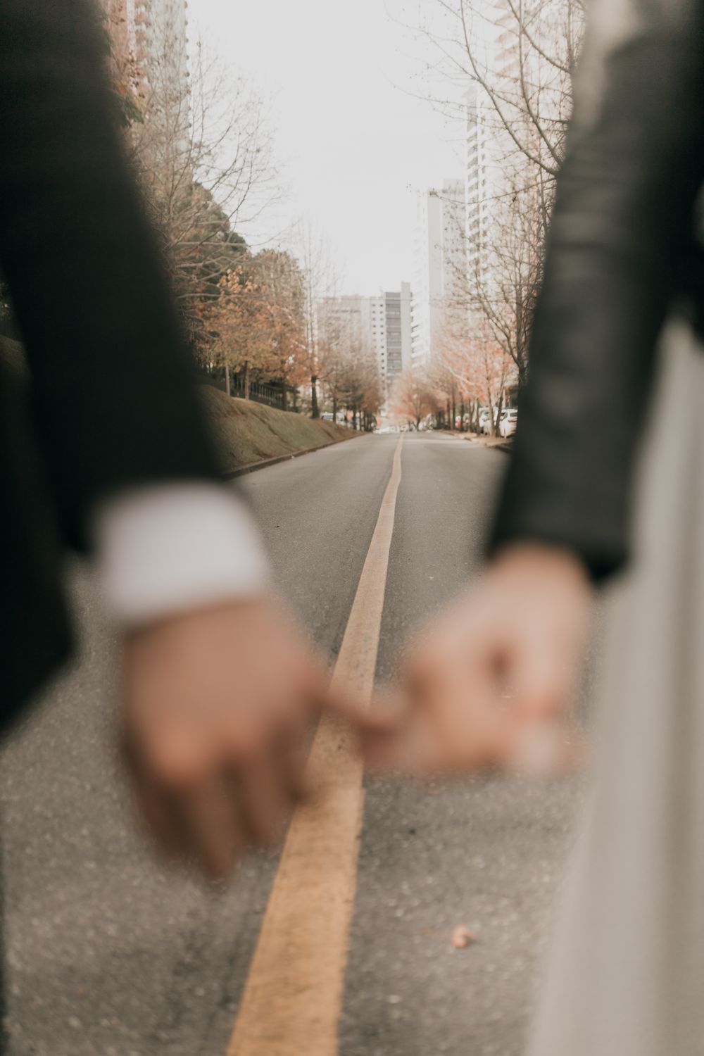 A romantic moment captured with a couple holding hands on a city street.